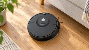 Black Roborock E5 robot vacuum on oak flooring beside a sofa